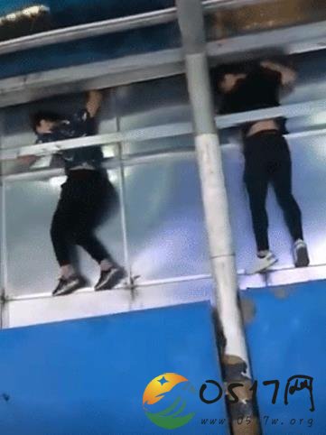 两男子翻广告牌进地铁站 想省钱也不是这么省的吧