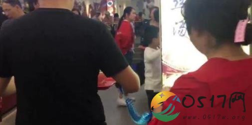 男子绳牵女友逛街 难道是害怕女友走丢了吗
